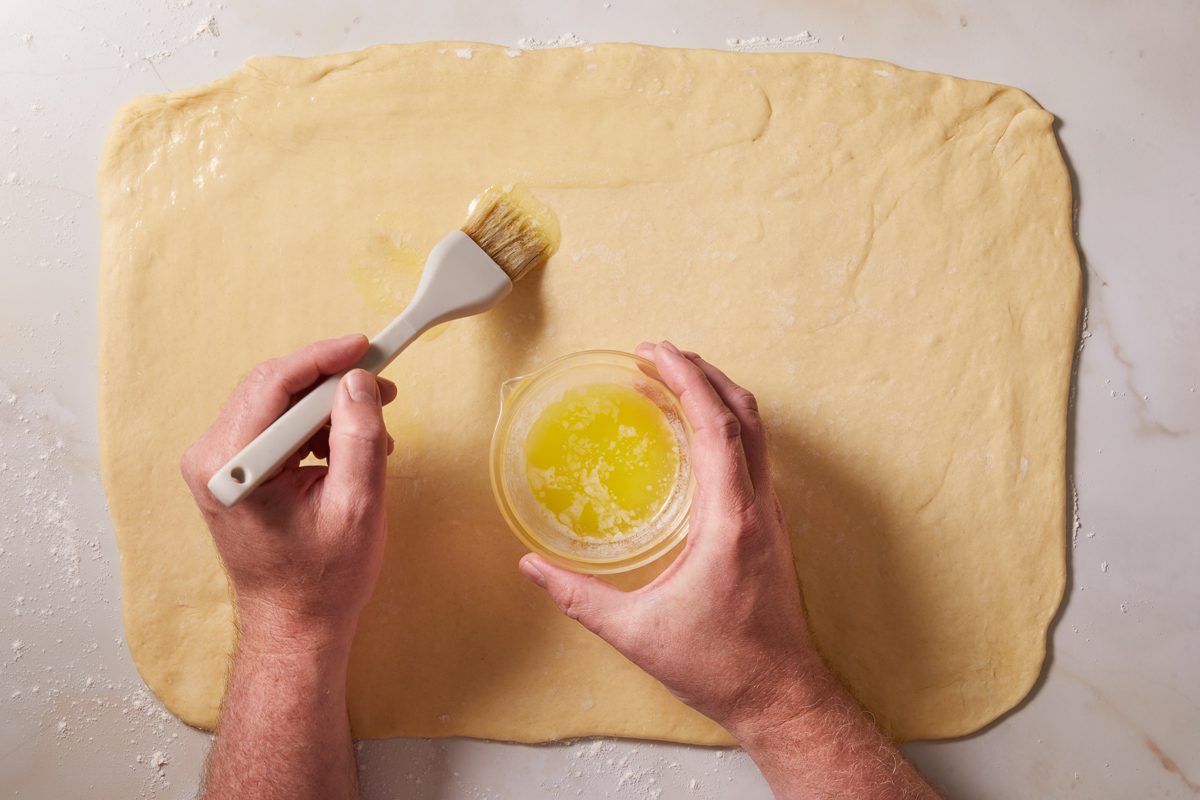 brushing dough with butter