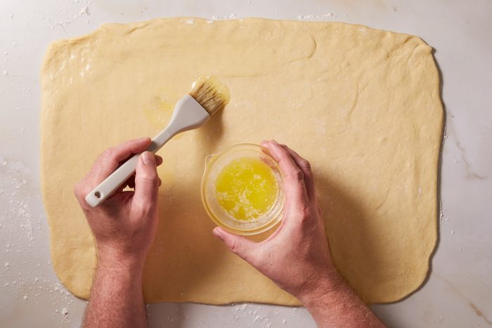 brushing dough with butter