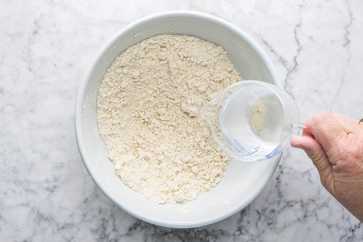 adding water to pastry mix in a bowl