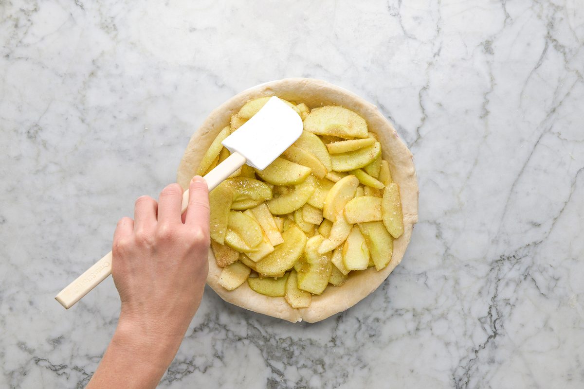 apple filling being added to pie plate
