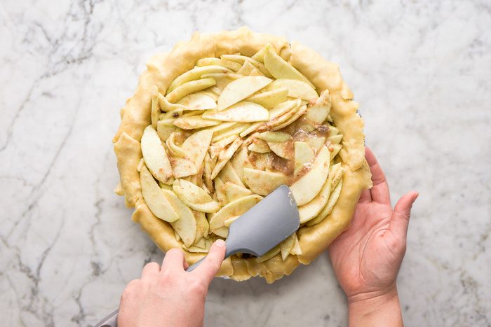 Pouring apple mixture into the pie shell