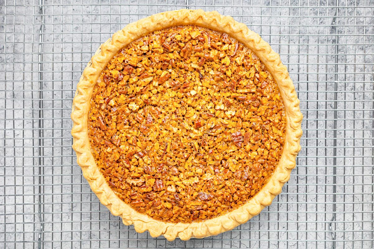 overhead shot of a pecan pie on a cooling rack