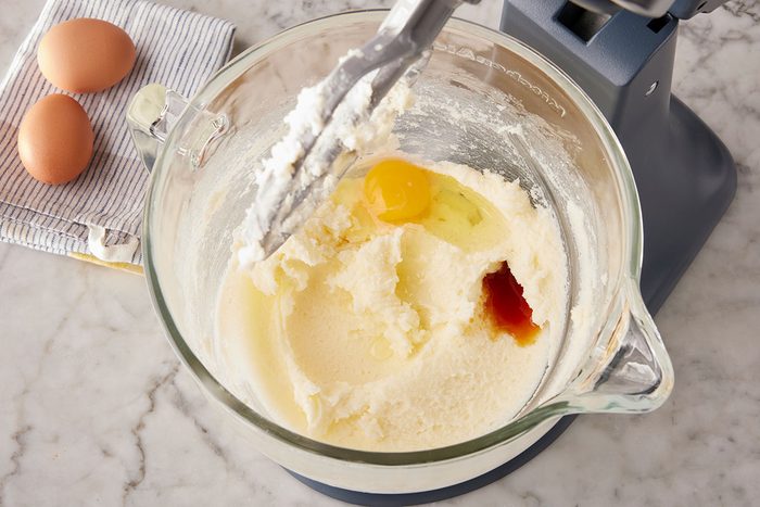 A egg is added in the mixture of softened butter and sugar in a stand mixer