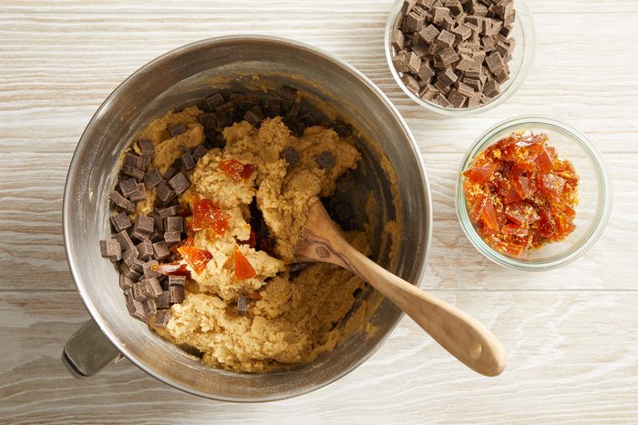 chocolate chunks and caramel pieces being mixed with flour mixture and brown sugar mixture