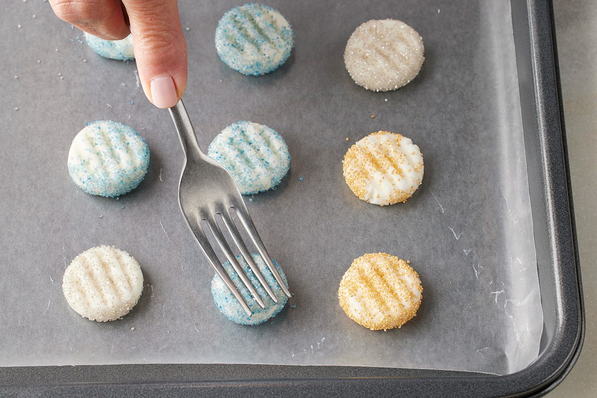 Close-up of a hand pressing a fork onto a round
