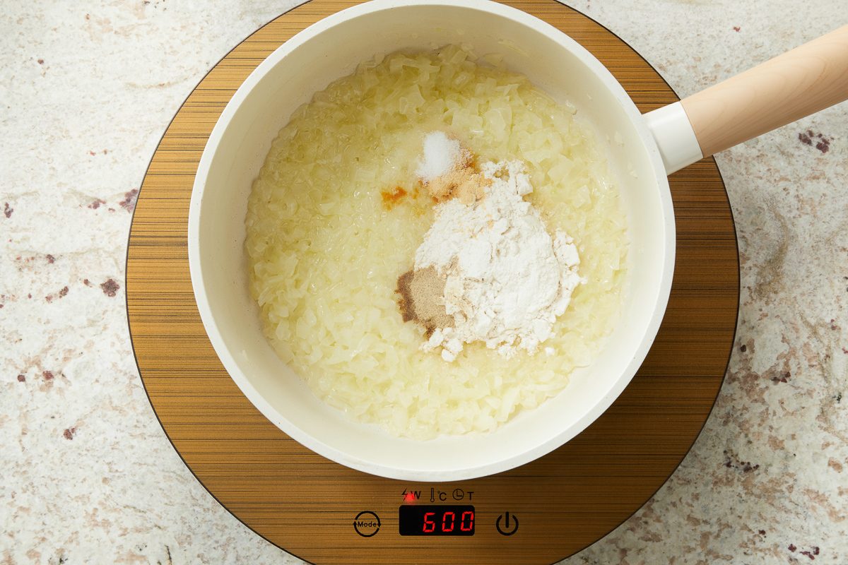 flour, salt, garlic powder and pepper added to onions being cooked in a pot
