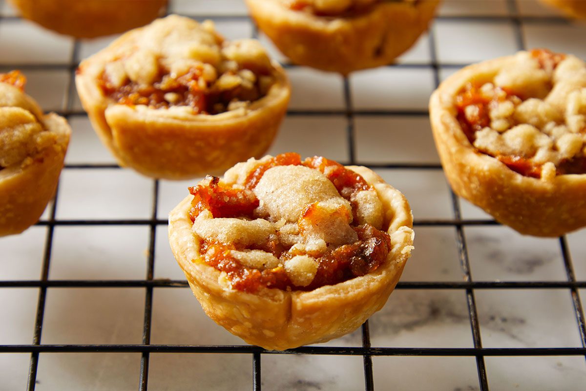 Close up shot of golden Mini Sweet Potato Pies cooling on a wire rack.