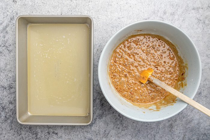 brown sugar, flour, eggs, vanilla, baking soda, salt and chopped pecans mixture next to melted butter in a baking pan