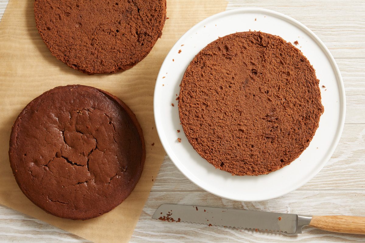 baked cake cut horizontally in half placed on a serving plate