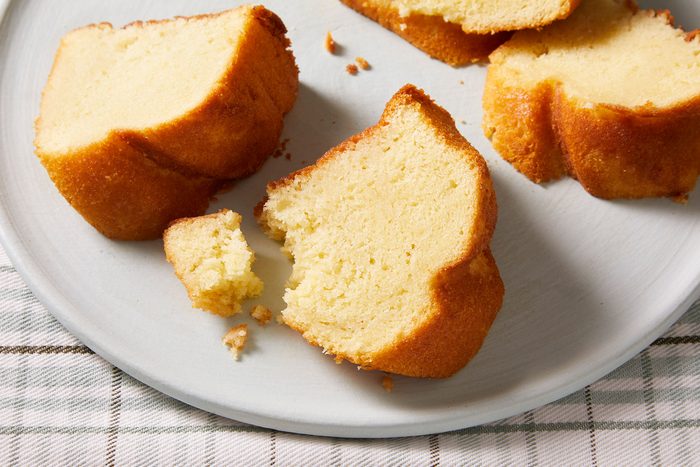 Coconut Rum Cake small pieces on a white dish placed on a checkered table cloth.