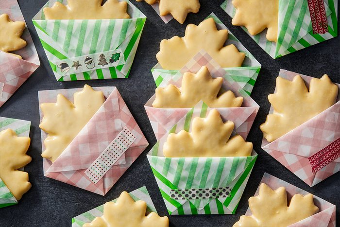 Glazed Maple ShortOverhead shot of Glazed Maple Shortbread Cookies tucked into origami folded envelopes made of green and pink patterned paper; each sealed with decorative washi tape and arranged on a dark surface;bread Cookies Tohcom25 Cookie Packaging Origami Folded Envelope With Washi Tap Md P2 10 16 10b
