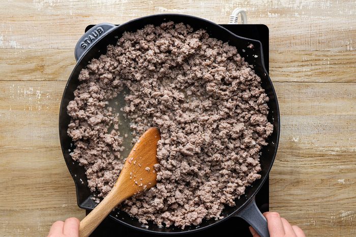 Cooking ground pork, garlic, cloves, nutmeg and cayenne pepper over medium heat in a large skillet.