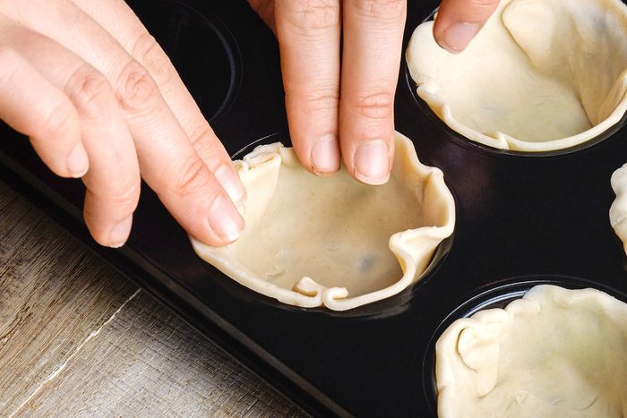 Placing the large circles in ungreased muffin cups, pressing the crust onto the bottoms and up the sides.