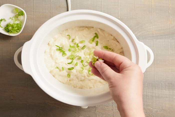 Sprinkling the dip with sliced green onions for a pop of color and fresh flavor.