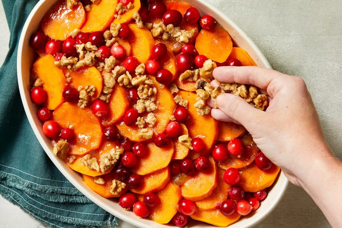 topping being sprinkled over sweet potato mixture