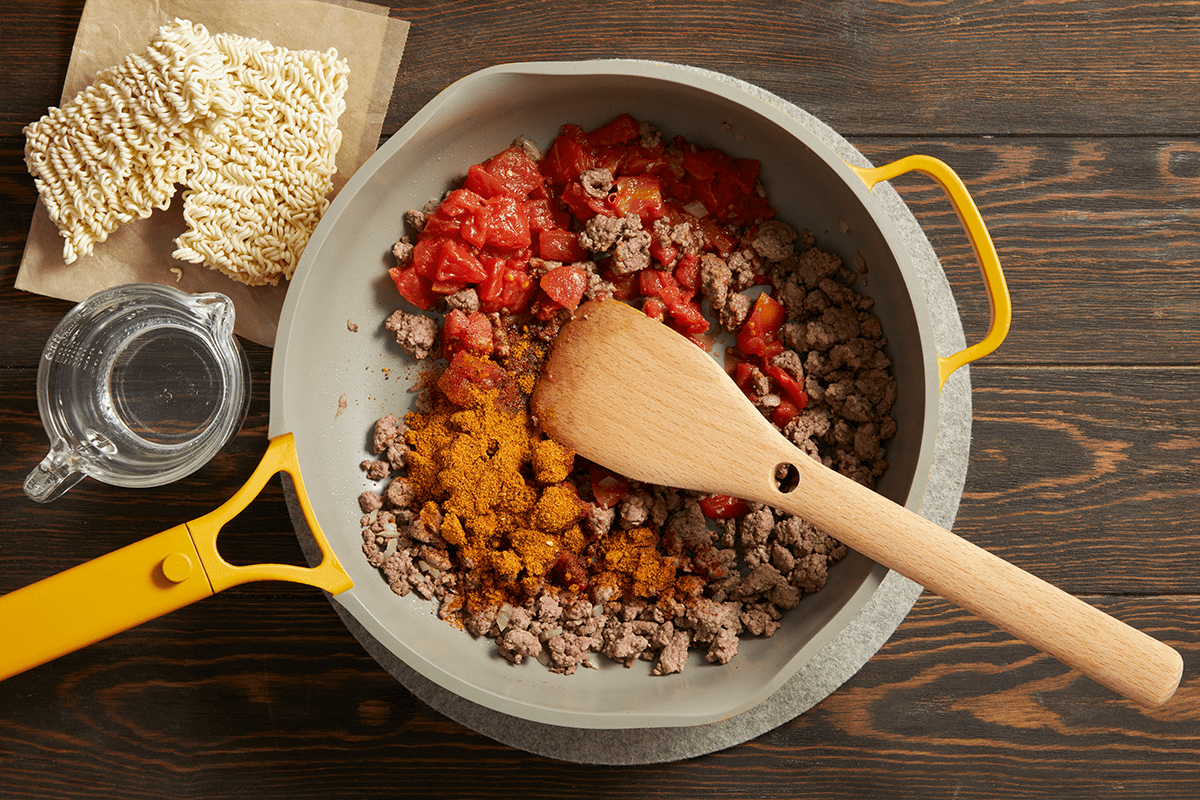 Cooking beef, onion, tomatoes and spices in a skillet