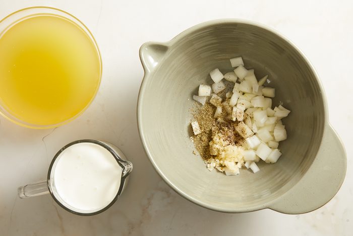onion, garlic, Italian seasoning and pepper in a large bowl next to chicken broth and heavy whipping cream