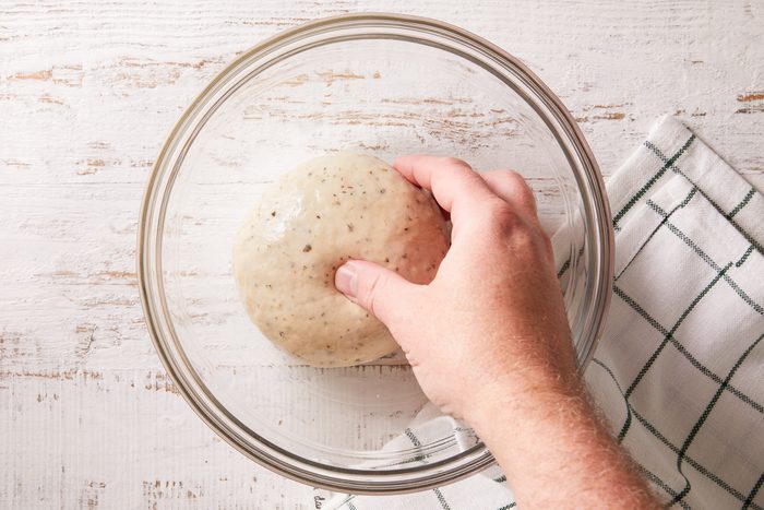 dough being placed in a greased bowl