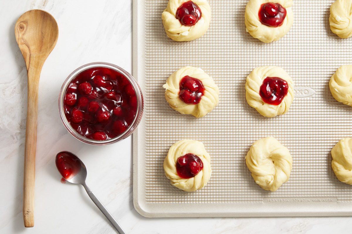 pastries on a tray filled with cherry pie filling