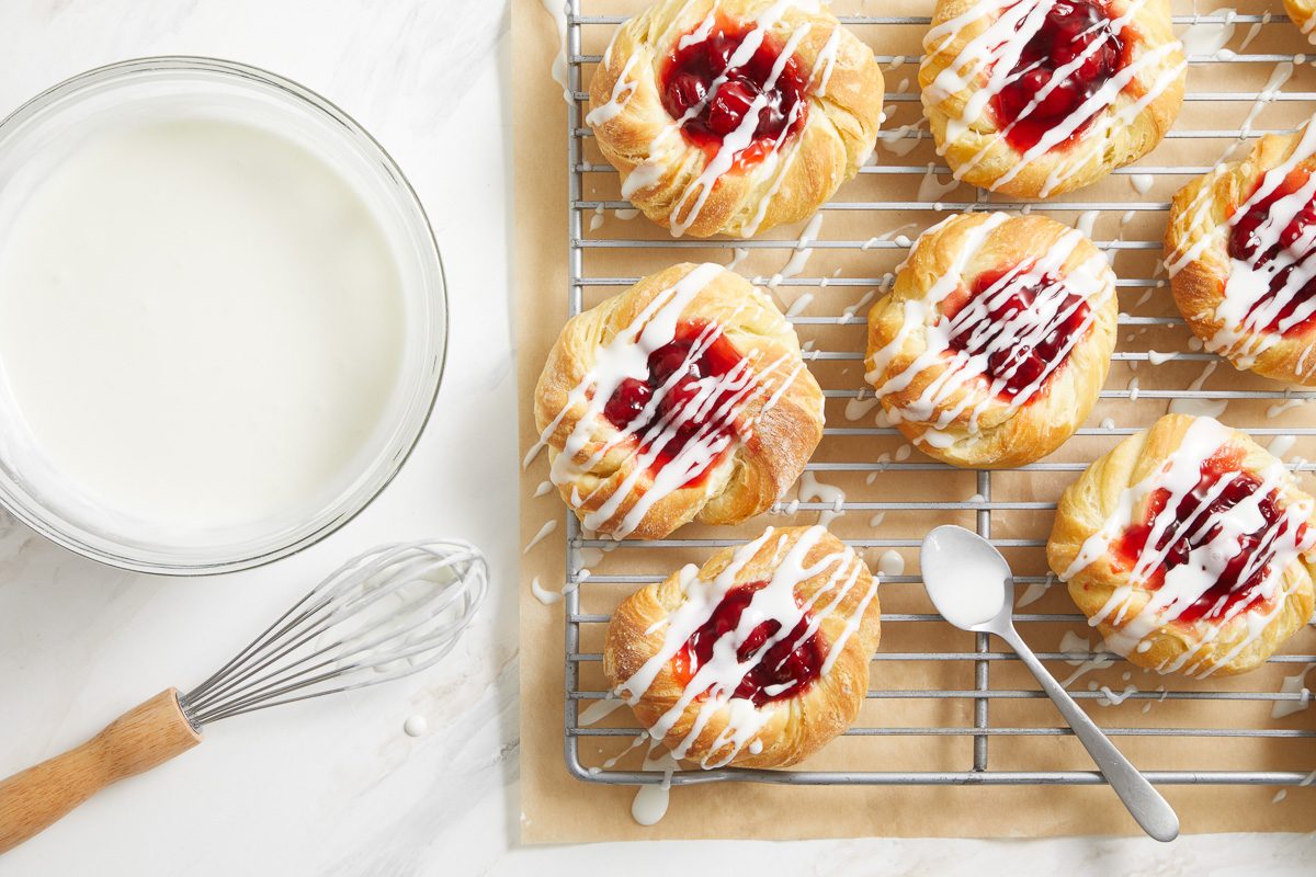 pastries on a wire rack iced with confectioners’ sugar, butter, vanilla and salt mixture