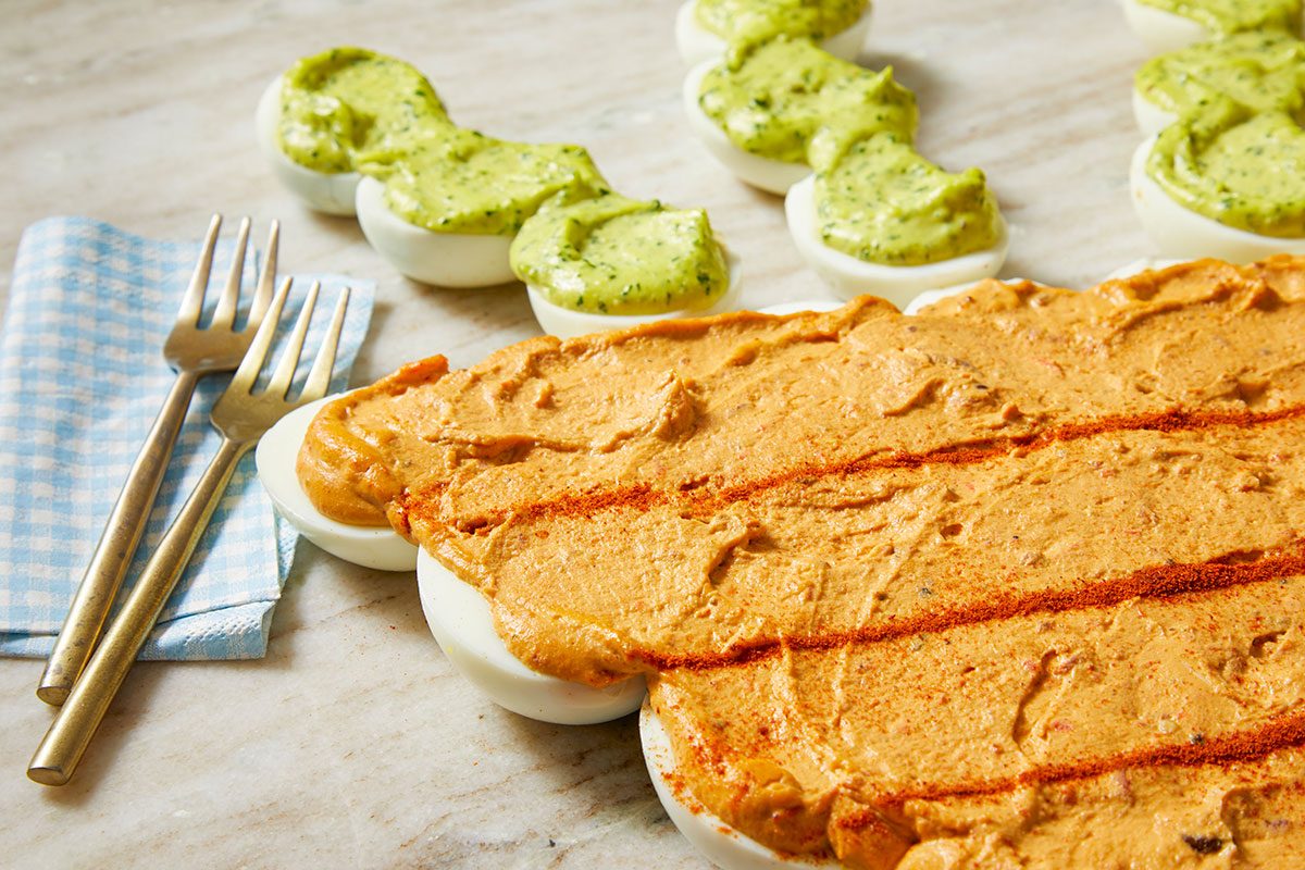 Overhead image of the pull-apart deviled egg carrot arranged for serving, with forks and napkins nearby to suggest a shared appetizer presentation.