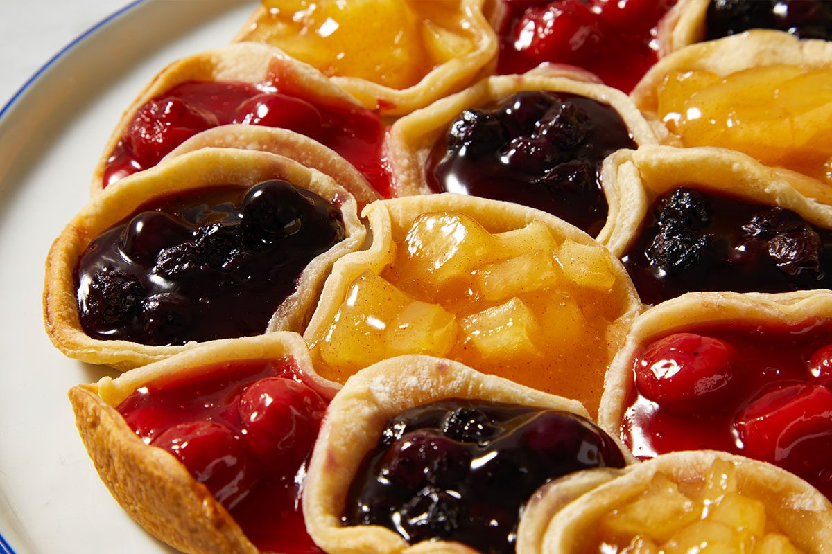 Overhead Push and Pulls close-up image highlighting the baked Pull-Apart Pie sections with glossy blueberry, cherry, and apple fillings nestled inside golden crusts. The tight framing emphasizes texture, color, and the pull-apart design.