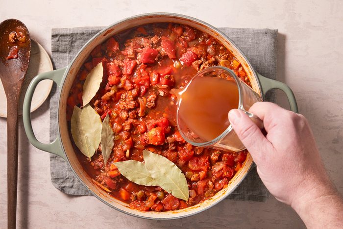 chicken broth being added to the stockpot